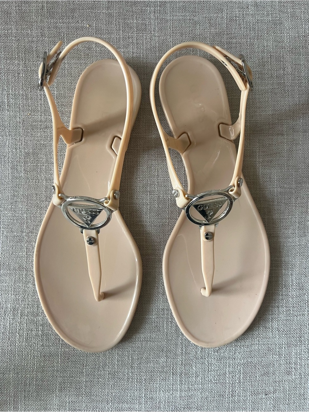 GUESS Women’s nude summer coquette Jelly T-Strap thong Sandals ,Silver Logo, 8